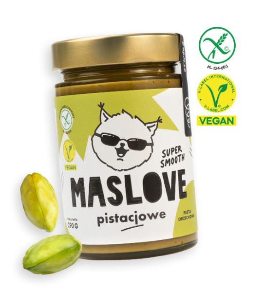Szklany słoik o pojemności 290 g z masłem pistacjowym od Maslove, o konsystencji super gładkiej Ozdobione etykietą z nazwą produktu oraz rysunkową wiewiórką w okularach. Produkt objęty certyfikatem wegańskim i bezglutenowym. Przy słoiku widnieje obrazek z orzechem pistacji.