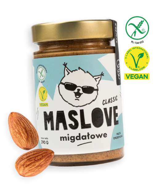 Szklany słoik o pojemności 290 g z masłem z migdałów od Maslove, w konsystencji klasycznej. Ozdobione etykietą z nazwą produktu oraz rysunkową wiewiórką w okularach. Produkt objęty certyfikatem wegańskim i bezglutenowym. Przy słoiku widnieje obrazek z orzechami migdałowca.